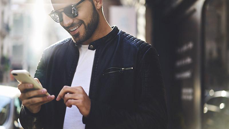 Man looking at mobile phone smiling